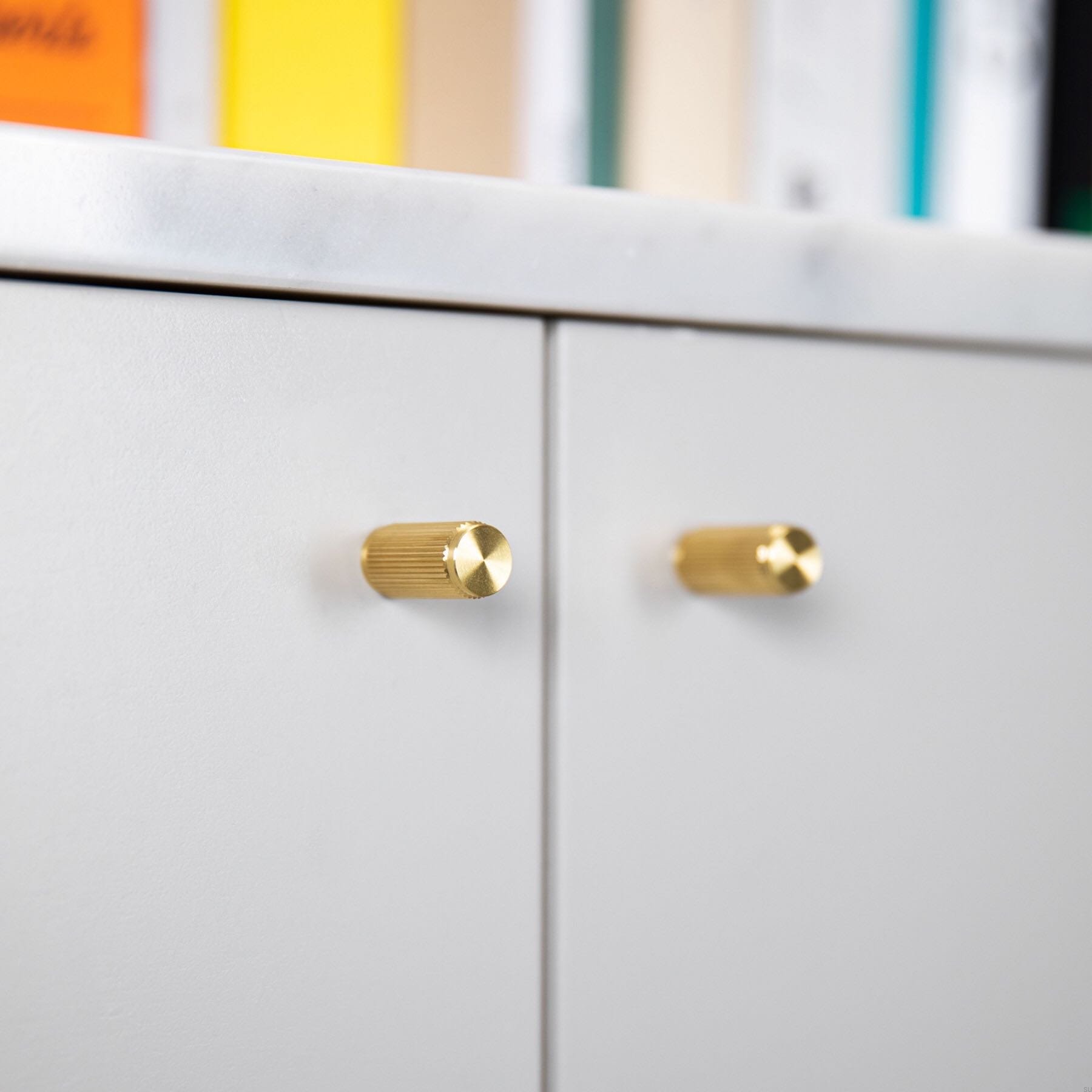 Zdjecie zestawu galek Linear mosieznego na meblu