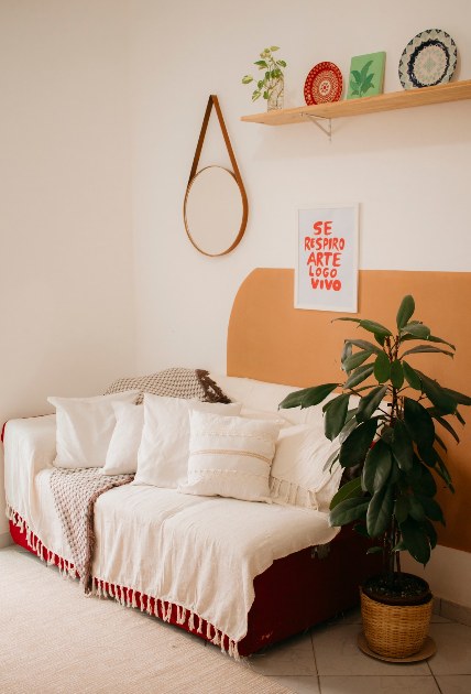 Salon w stylu boho z sofa, roslinami i naturalnymi dodatkami